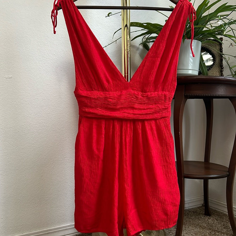 Red v-neck romper with shoulder ties and pockets